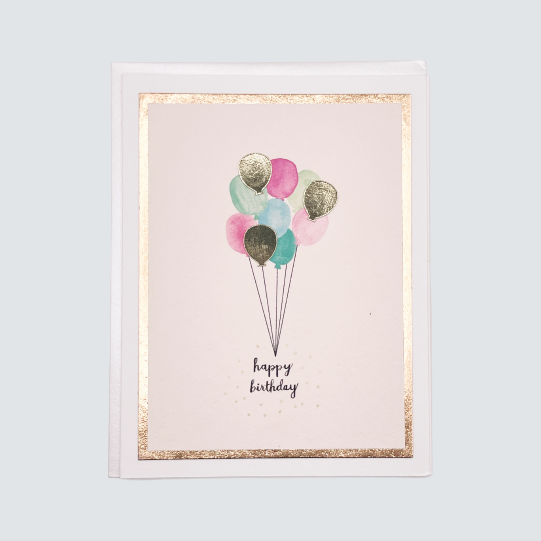 Handmade birthday balloons card with watercolor balloons and rose gold foil accents, blank inside.