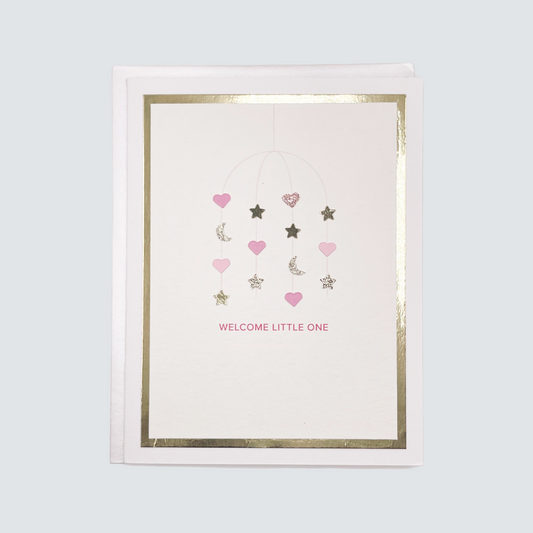 Handmade pink baby card with watercolor mobile design and gold foil accents, blank inside on white cardstock.
