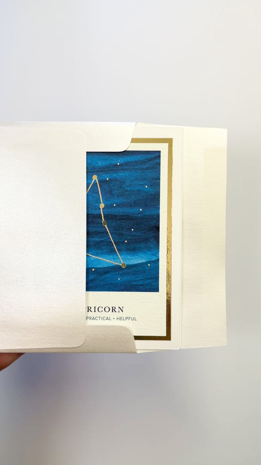 Handmade Capricorn zodiac constellation card with watercolor sky and gold foil accents, blank inside on FSC-certified cardstock.