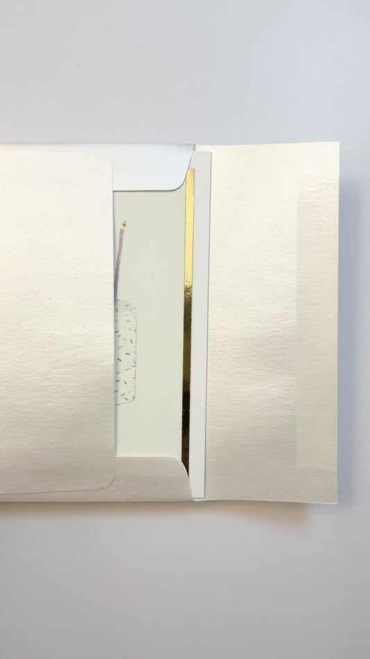Hands opening an envelope to reveal a handmade funfetti birthday card with gold foil and watercolor sprinkles.
