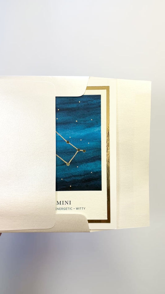 Handmade Gemini zodiac constellation card with watercolor night sky and gold foil accents, blank inside on premium cardstock.