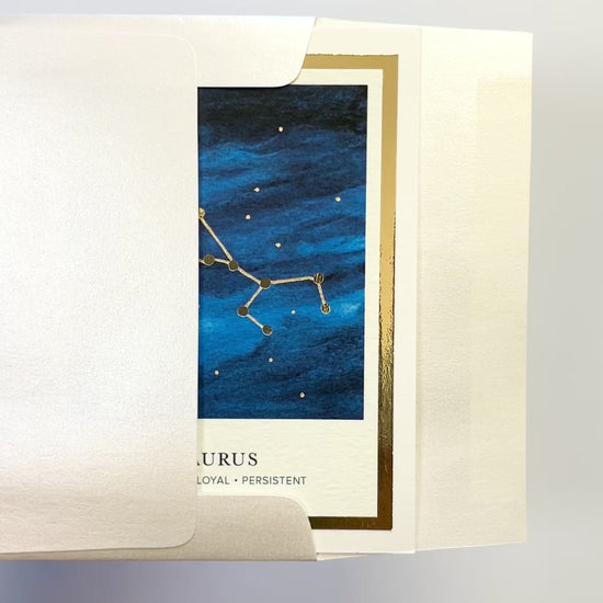 Handmade Taurus zodiac constellation card with watercolor night sky and gold foil details, blank inside on premium FSC-certified cardstock.
