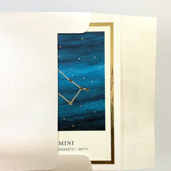 Handmade Gemini zodiac constellation card with watercolor night sky and gold foil accents, blank inside on premium cardstock.